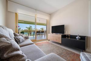 Una sala de estar con un sofá y un televisor de pantalla plana. en Apartamento Pelicano, en Cambrils