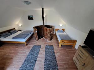 a room with two beds and a fireplace at Hármas Apartman - Zsóryfürdő Mezőkövesd in Szihalom