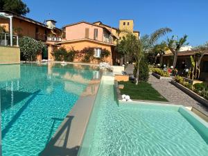 una piscina con acqua blu di fronte a un edificio di Antica Locanda Palmieri a Roma