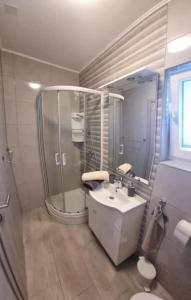 uma casa de banho com um chuveiro, um lavatório e um WC. em Matoc apartments em Murter