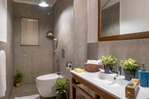 a bathroom with a sink and a toilet and a mirror at Nyara Fontainhas Panaji - Heritage villa Goa in Panaji