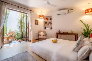 ein Schlafzimmer mit einem weißen Bett und einem großen Fenster in der Unterkunft Nyara Fontainhas Panaji - Heritage villa Goa in Panaji