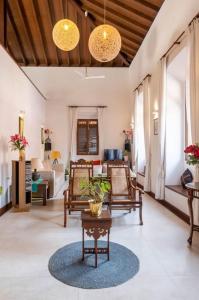 un soggiorno con sedie e tavolo di Nyara Fontainhas Panaji - Heritage villa Goa a Panaji
