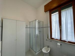 La salle de bains est pourvue d'une douche en verre et de toilettes. dans l'établissement Nuova ristrutturazione a due passi dal Mare, à Castiglione della Pescaia