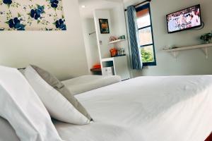 a white bed with white pillows in a bedroom at Cruiser Island By Swiss-Belhotel in Ko Lone