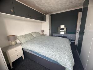 ein kleines Schlafzimmer mit einem Bett und einem Nachttisch mit einem Bett sidx sidx sidx in der Unterkunft Charming house welcome in Cardiff