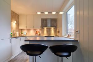 a kitchen with two black stools at a counter at Perfekt base for det meste! in Leknes +12 photos