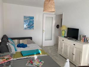 een kleine kamer met een bed en een tv op een kast bij Appart proche plage avec grand balcon in Cannes