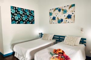two beds in a room with flowers on the wall at Cruiser Island By Swiss-Belhotel in Ko Lone