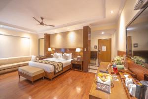 um quarto de hotel com uma cama e um sofá em Divine Resort & Spa em Rishikesh