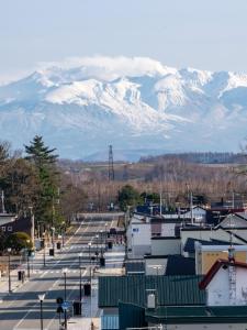 a city with snow covered mountains in the background at UU HOME - Vacation STAY 28487v in Biei