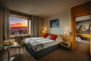 a hotel room with a bed and a large window at Cosmopolitan Bobycentrum - Czech Leading Hotels in Brno