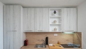 a kitchen with white cabinets and a sink at Iole's House, finestra sul mare in Olbia