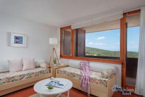 a living room with a couch and a large window at Iole's House, finestra sul mare in Olbia