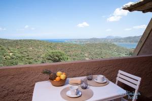 a table with a basket of fruit on a balcony at Iole's House, finestra sul mare in Olbia