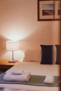 a bedroom with a bed with a lamp on a table at Seaview Retreat in Adventure Bay