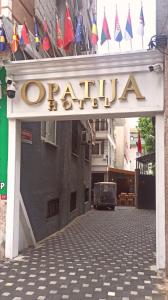 una señal para un restaurante en un edificio con banderas en Opatija Hotel, en Estambul