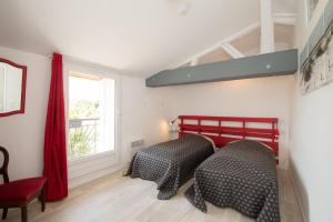 two beds in a room with a window at GITE LA BLANCHE LONGERE in Compertrix