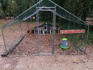 Emplacement tente camping car في Saint-Aubin-de-Nabirat: قفص الضرب مع منزل الطيور ولعبة