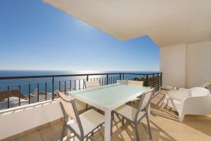a balcony with a table and chairs and the ocean at Apartamento de 2 dormitorios en Torrox Costa in Torrox Costa