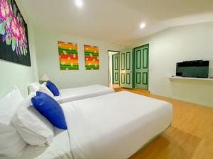 a bedroom with two beds and a flat screen tv at Cruiser Island By Swiss-Belhotel in Ko Lone