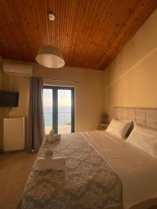 a bedroom with a large bed with a view of the ocean at Rozos House in Loutsa