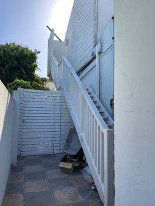 een trap naar een gebouw met een witte trap bij Mountain View flat in Kaapstad