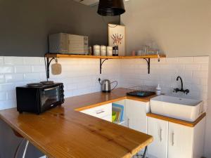 a kitchen with a counter with a microwave and a sink at Mountain View flat in Cape Town