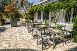 - une rangée de tables et de chaises sur la terrasse dans l'établissement Hotel Le Patio - Deauville, à Deauville