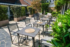 a group of tables and chairs on a patio at Hôtel Le Patio - Deauville in Deauville