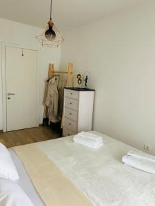 um quarto com uma grande cama branca e uma cómoda em DeVigo em Zadar