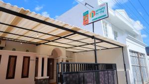 a pergola on a house with a sign on it at Homestay Jogja Dekat Taman Pelangi by Simply Homy in Yogyakarta