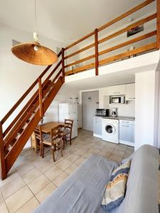Pokój z klatką schodową, stołem i kuchnią w obiekcie Appartement 4 personnes piscine 300 plage 4PB287 w mieście Le Barcarès