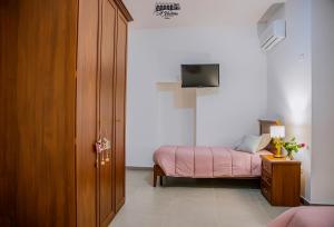 una camera con letto e armadio in legno con televisore di 'A Vadera a Ruviano