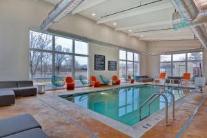 a swimming pool with chairs and a couch at Aloft Secaucus Meadowlands in Secaucus