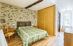 - une chambre avec un lit et un mur en pierre dans l'établissement 1 Bedroom Stunning Home In Galicia, à Belesar