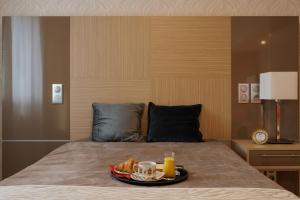a tray of food on a bed with a plate of food at Appart One Aix-les-Bains in Aix-les-Bains