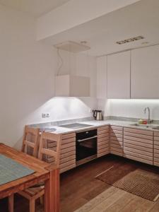 cocina con armarios blancos, mesa y fogones en Apartament Villa Łyna Park, en Olsztyn