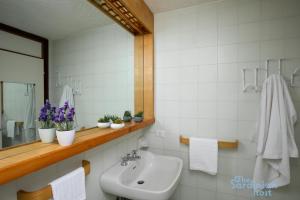 a bathroom with a sink and a mirror at Iole's House, finestra sul mare in Olbia