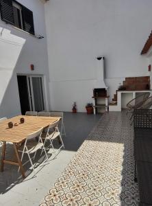 eine Terrasse mit einem Holztisch und Stühlen in einem Gebäude in der Unterkunft Casa da Paz #1 in Vila Nova de Milfontes