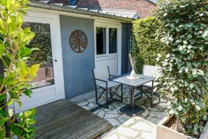 a patio with a table and chairs next to a door at Hôtel Le Patio - Deauville in Deauville