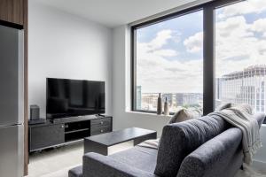 a living room with a couch and a large window at Seaport 1BR w Gym Pool WD Doorman BOS-280 in Boston