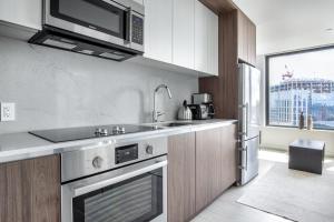 a kitchen with a stainless steel oven and a microwave at Seaport 1BR w Gym Pool WD Doorman BOS-280 in Boston