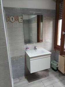 een badkamer met een witte wastafel en een spiegel bij B&B Perbaccobar in Ono San Pietro