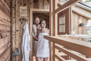 施勒肯的住宿－Aadla Walser-Chalets mit privater Sauna, Hotpot und Hotelservice，站在浴室里的男女