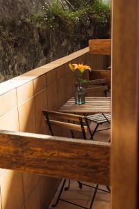 a table with a vase of flowers on a balcony at San Sebastián DOT Rooms in San Sebastián