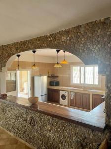 a kitchen with a stone wall with a counter top at Une Maison en pierre in Ndayane