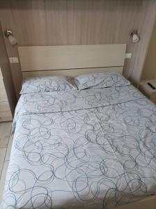 een bed in een slaapkamer met een deken erop bij B&B Perbaccobar in Ono San Pietro