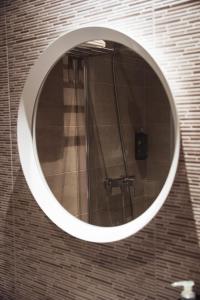 a round mirror on a wall with a shower at San Sebastián DOT Rooms in San Sebastián