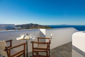 un tavolo e sedie su un balcone con vista sull'oceano di Horizon Hotel a Chora Folegandros